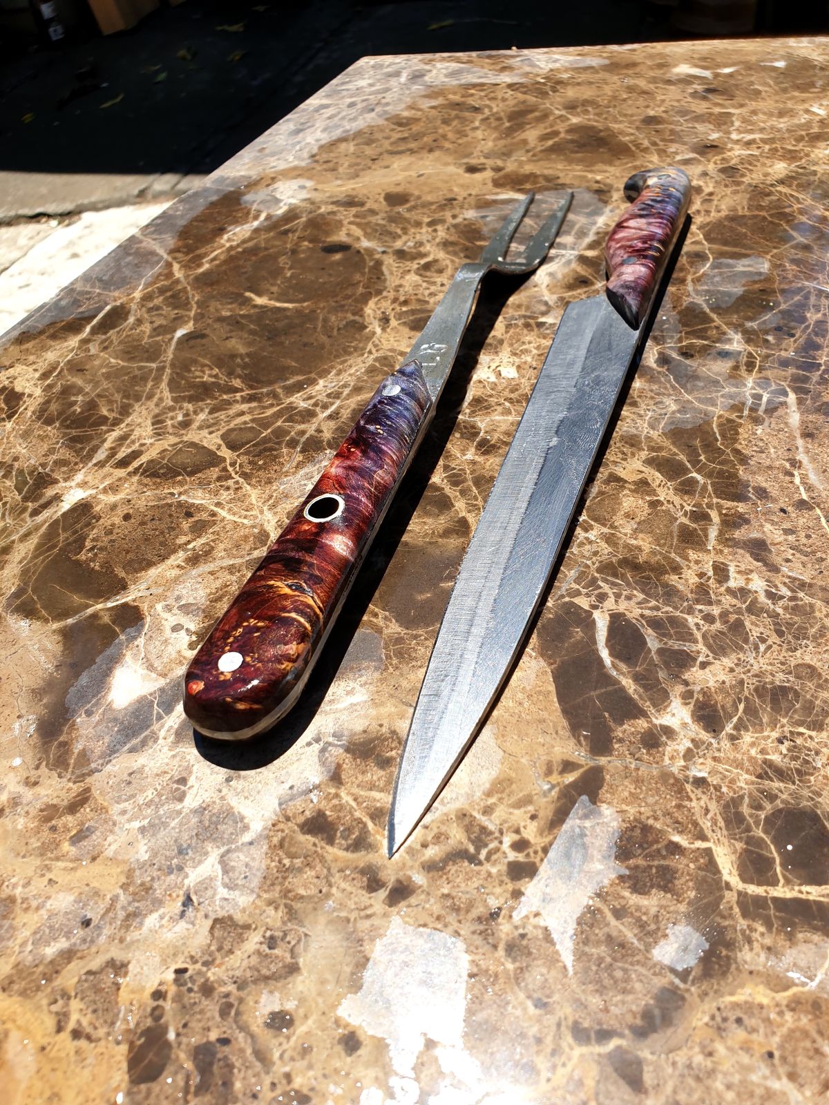 A carving fork and carving knife with matching timber handles
