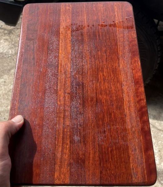 A restored timber chopping board with a deep red finish