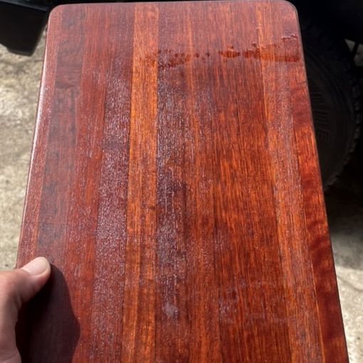 A restored chopping board with a deep red timber finish