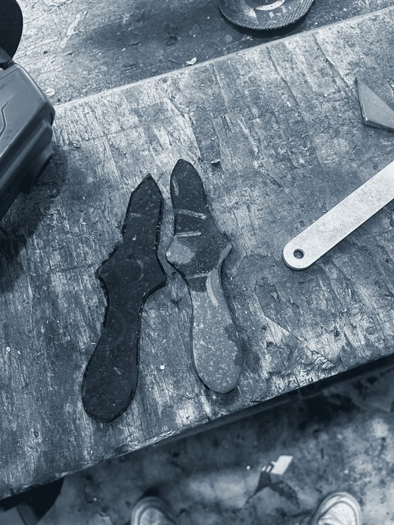 Rough steel blanks cut to the knife shape, covered in rust